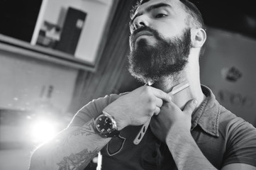 Beautiful manly bearded man in a barbershop on a beard styling