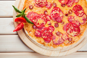 Meat Pizza with tomatoes on the wooden background