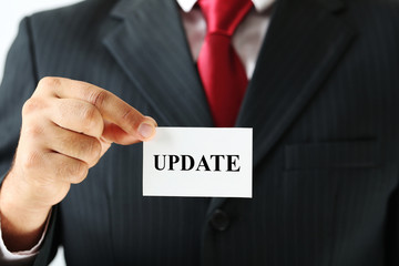 Businessman holding card with word Update