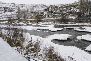 Old buildings by frosted river in Kars,Turkey