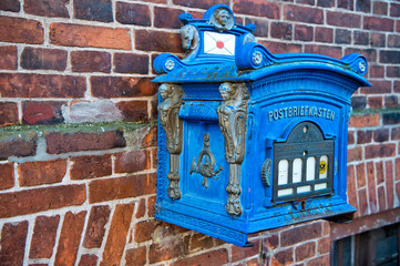 Fototapeta na wymiar Post box blue color on red brick wall background