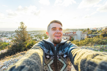 Handsome man is taking a selfie outdoor - caucasian people - nature, people, lifestyle and technology concept.