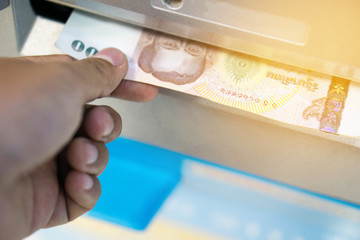 man receive money from the automated teller machine.people withdraw money from ATM and get it from money box or dispenser at cash point with light