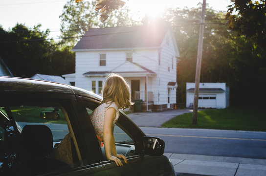 Girl leaning out of front car window
