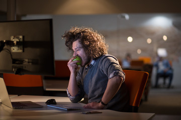 man eating apple in his office