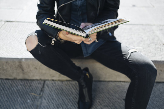 Fashionable woman reading a book outdoor