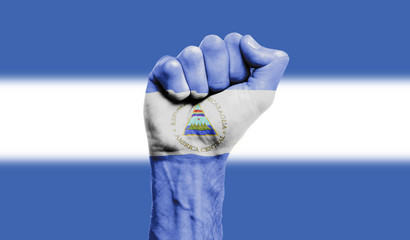 Nicaragua flag painted on a clenched fist. Strength, Power, Protest concept