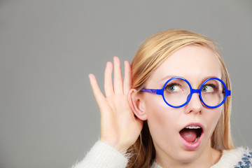 Woman listening carefully with hand close to ear