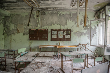 abandoned class room with furniture and debris in Pripyat