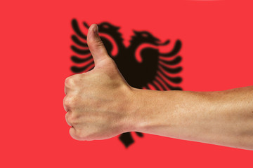 Thumbs up on a background of a flag of Albania