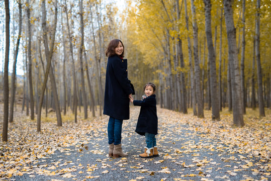 Cute little girl and her mother in the forest