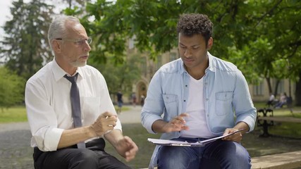 Literature teacher giving advice to Hispanic student about essay writing