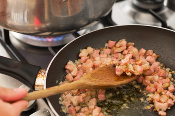 Preparation of bacon with onions in a frying pan