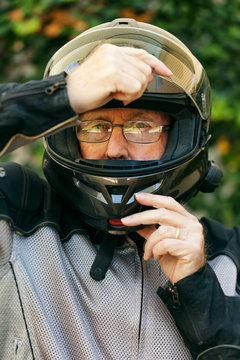 Rider: Senior Male Adjusts Helmet