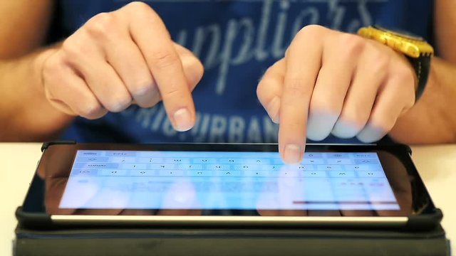 Close-Up of Male Hands Typing an Email on Tablet Touchscreen Computer 