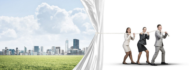 Young businesspeople working in collaboration and pulling white advertisement banner