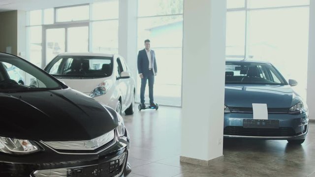 The salesman on gyroscope shows a thumb up in the car dealership