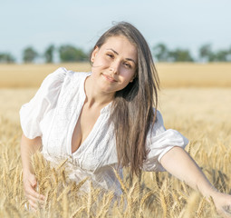 Portrait of a pretty sexy female in wheat field at warm summer day