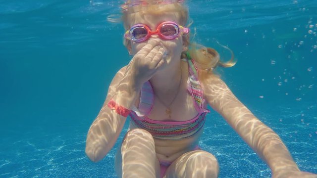 Girl 6 years old learns to dive in the pool. Underwater video