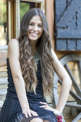 Portrait of a beautiful smiling young girl wearing a dress dress while sitting