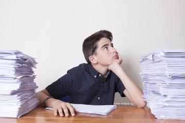 child student on the desk with stacked papers