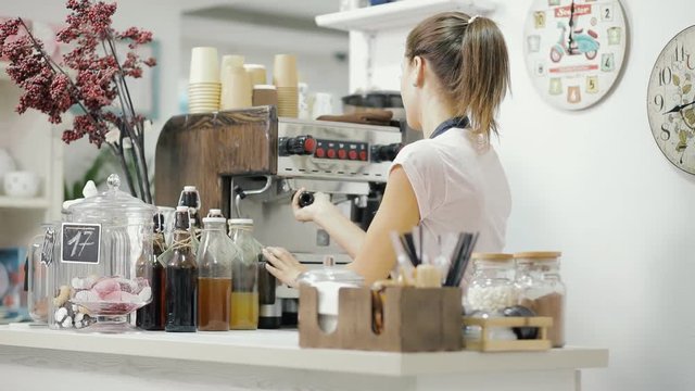 Female barista working, she make coffee for a client