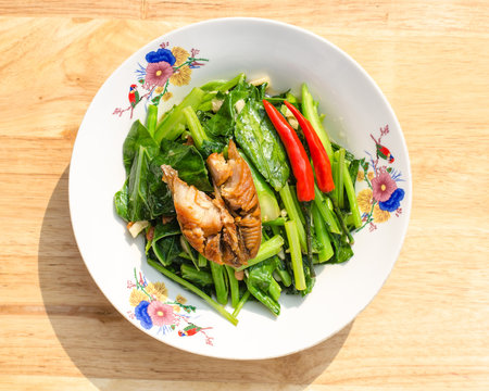 Stir fried kaled and sun dried salted fish with oyster sauce in plate, chinese broccoli and sun dried salted fish with oyster sauce in plate, Thai food, Thailand