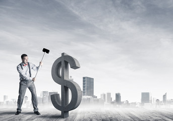 Determined banker man against modern cityscape breaking dollar c
