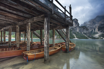 boats under old embankment on the lake in Italy
