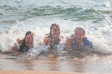 Waves Splash Girls Laying on the Sand