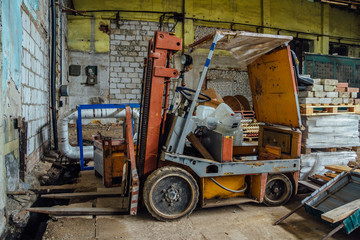 Fototapeta na wymiar Old forklift in abandoned warehouse