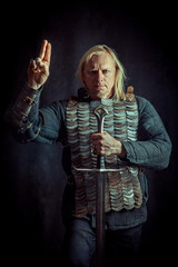 Portrait of praying Templar knight on a dark background.