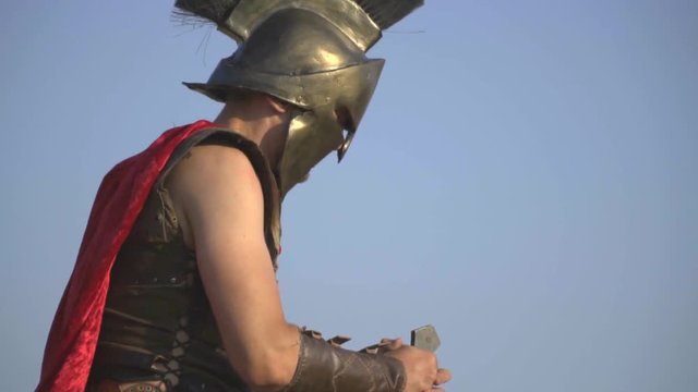 Roman legionary in armor with a weapon in his hand stabs a sword into the belly of a lying opponent