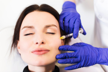 Naklejka premium A woman on the procedure of injections in a cosmetology clinic