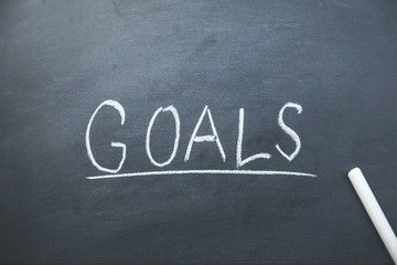 "Goals" handwritten with white chalk on a blackboard