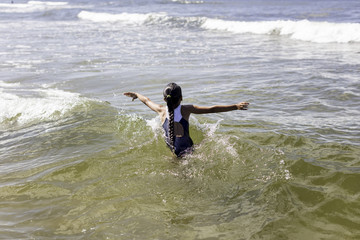 dziewczynka w kostiumie kompie się w morzu bałtyckim