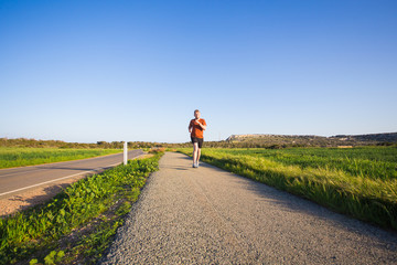 Obraz premium Athletic young man running in the nature. Healthy lifestyle.