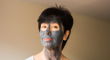 Beautiful woman with facial mask. Cosmetology, spa, skin care and people concept.