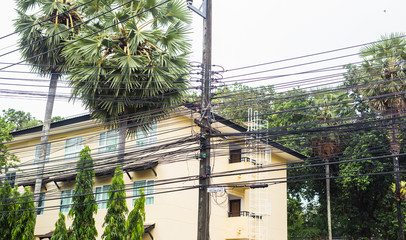 Messy electrical cables in thailand - Uncovered optical fiber technology open air outdoors asian cities.