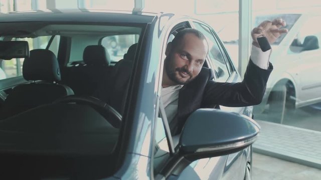 Happy buyer with keys in car dealership