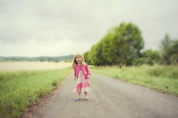 Fototapeta premium Happy little girl run and jump on road