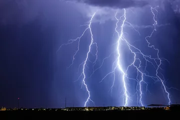 Photo sur Aluminium Orage Lightning storm over city lights.