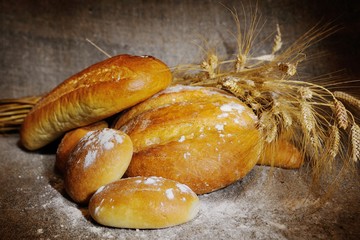 bread, loaf, white bread, wheat ears on a background of burlap. Agriculture. harvest