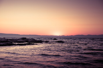 Fototapeta na wymiar Sunrise horizon / Beautiful beach in Greece while sun rising over the sea