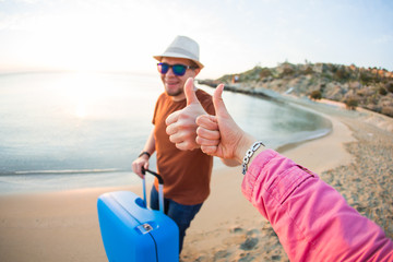 summer holidays and vacation - man and woman showing thumbs up on the beach