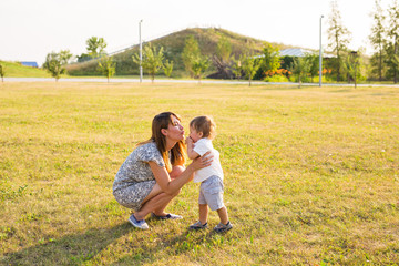 Fototapeta premium Cute cheerful child with mother play outdoors in park