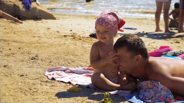 Little girl strokes her father on the head