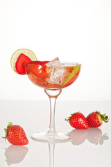 Cocktail with champagnem strawberries and lime standing on the glass table