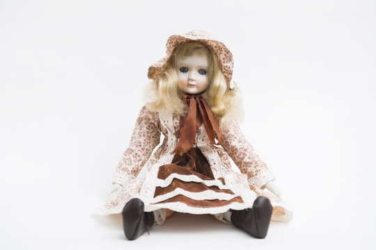 Ceramic porcelain handmade blond doll with textile hat and brown dress
