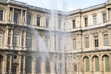 Obraz premium Inner courtyard and exterior of The Louvre Museum with walking tourists in a summer day